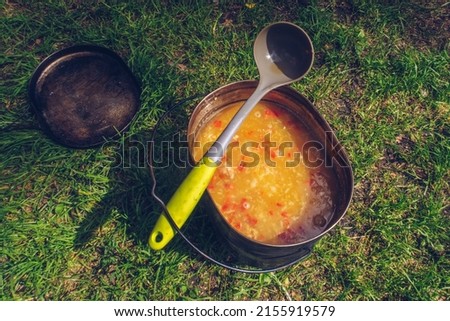 Camping pot with mouthwatering soup meal. Outdoor stew food. Wildlife lifestyle cooking delicious meal. Eat outside. Copyspace stock photography