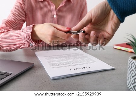 Businessman giving pen to business woman ready to sign contract. Success communication at meeting or negotiation. Man's hand giving a pen to a client to sign a contract.
