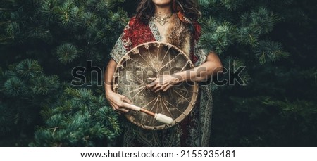 shamanic girl playing on shaman frame drum in the nature. Royalty-Free Stock Photo #2155935481