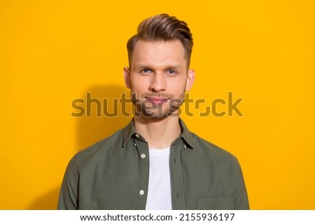 Portrait of attractive content blond guy wearing khaki shirt isolated over vibrant yellow color background
