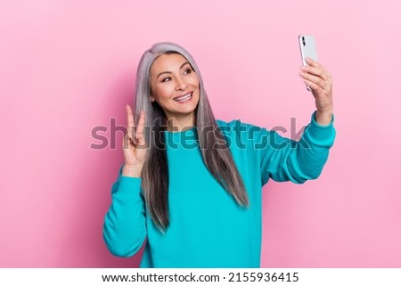 Photo of positive person make selfie hand fingers demonstrate v-sign isolated on pink color background