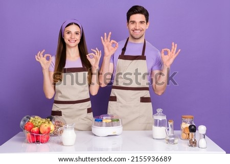 Photo of pretty sweet boyfriend girlfriend dressed chef showing okey signs isolated purple color background