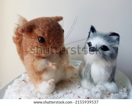 The needle felted handmade squirrel doll and Siberian Husky dog figure are new friends with white background. original photo