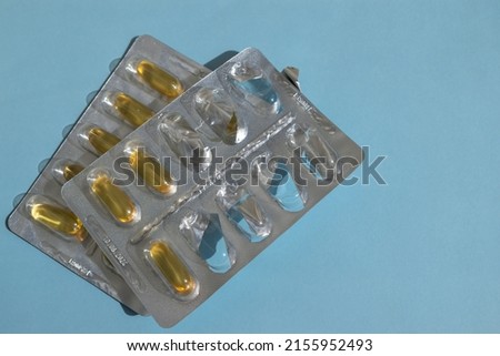 Pills in a blister close-up on a blue background. Import of tablets. Treatment. Healthy lifestyle.
