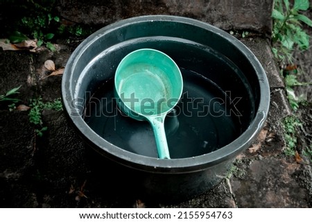 PLASTIC WATER CONTAINER WITH ONE BLUE DIPPER