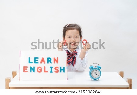 The lovely little girl is learning letters