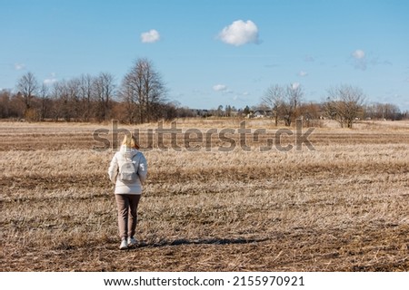 Woman walking on field against sky