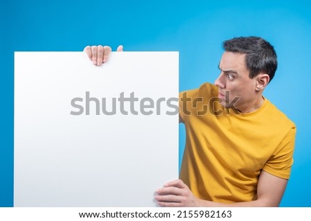 Surprised male model looking at blank banner