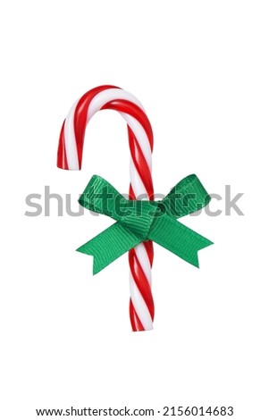 Red and white Christmas candy cane with light green ribbon bow isolated on white background