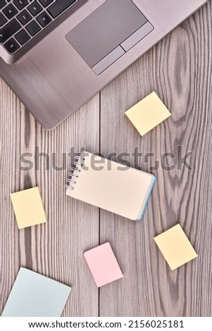 Vertical shot blank notepads and silver laptop pc. Top view flat lay.
