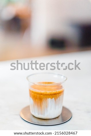 Coffee dirty menu - A glass of espresso shot mixed with cold fresh milk in coffee shop cafe and restaurant.vertical coffee dirty picture in cafe.specialty coffee.food beverage menu.japan drink idea.