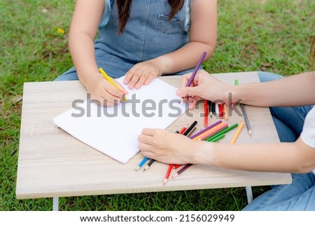Children's hands are drawing and painting with color pencils. with a parent or teacher
