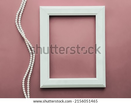Vertical frame and pearl jewellery on blush pink background as flatlay design, artwork print or photo album concept