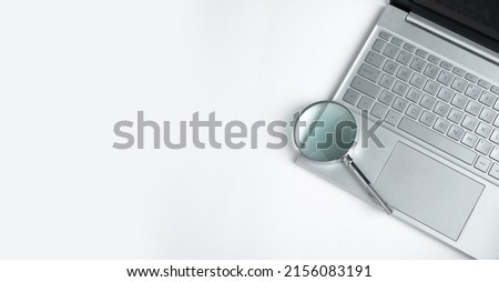 Technology banner with laptop keyboard and magnifying lens with copy space for text. High quality photo