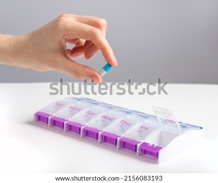 Hand taking capsule from pill case, bbo, organizer. High quality photo