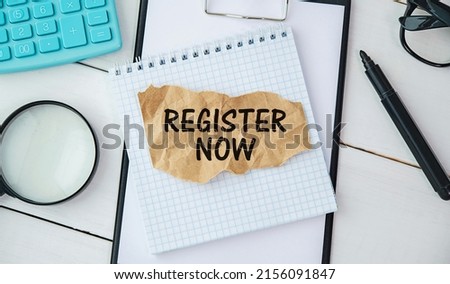 Membership concept. Template for registration. Register now hand lettering iconon word desk with glasses, coffee, plant on dark wooden background top view space for text