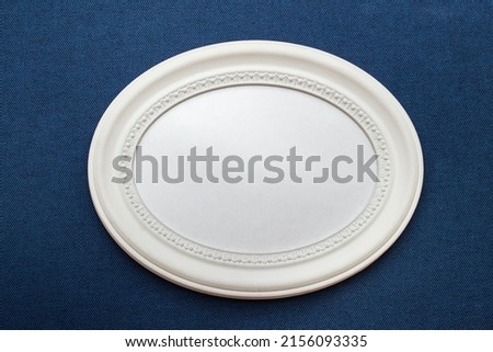 Mockup template with oval white frame on blue navy textured cloth fabric.