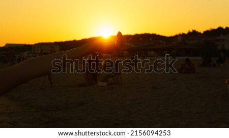 Woman hand holding sun on beach sunset. 