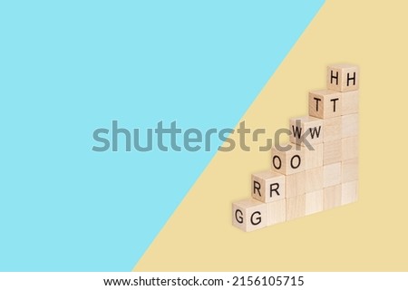 Wooden cubes block which print screen growth wording on blue and yellow background. Target of investment and business growth concept.