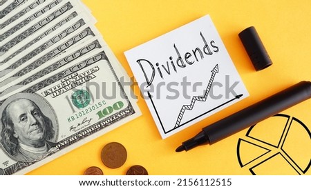 Dividends are shown using a text and photo of dollars Royalty-Free Stock Photo #2156112515