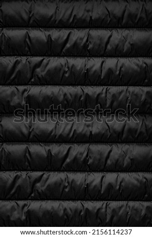 Texture of puffer, padded, down jacket. Background of urban winter outfit. Quilted pattern. Royalty-Free Stock Photo #2156114237