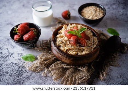 Oatmeal porridge with strawberries in a bowl. toning. selective focus