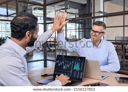 Two happy successful excited diverse traders investors giving high five celebrating successful stock exchange trading deal, rising crypto bull market shares growth, ipo profit victory concept. Royalty-Free Stock Photo #2156127853