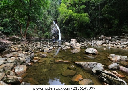 Asian woman standing on the rock near the Yong Waterfall (Namtok Yong) in Yong Waterfall National Park, Nakhon Si Thammarat, south of Thailand Royalty-Free Stock Photo #2156149099