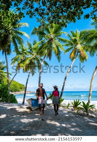 Mahe Seychelles, a tropical beach with palm trees, and a blue ocean at Mahe Seychelles. Anse Takamaka beach Mahe Seychelles. couple man and woman on vacation Seychelles