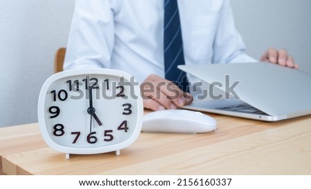 Clock on the desk. A businessman who works. Royalty-Free Stock Photo #2156160337