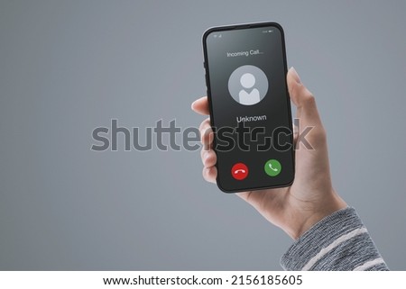 Woman receiving a call on her smartphone from an unknown number, malicious phone calls concept, POV shot Royalty-Free Stock Photo #2156185605