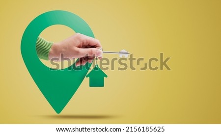 Hand holding house keys and location pin, real estate concept Royalty-Free Stock Photo #2156185625