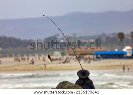 View of a person fishing from behind. Fishing pole and bait.