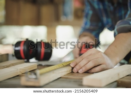 Hands of person doing diy project at home. Man measuring wood to doing cabinet craftworks as a hobby. Royalty-Free Stock Photo #2156205409