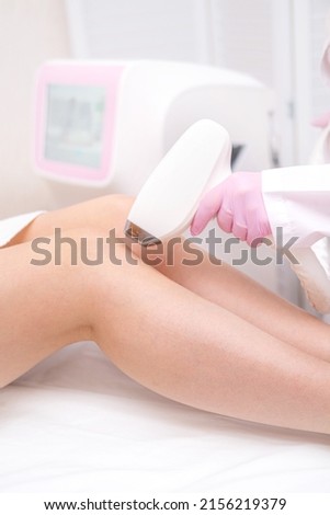 Diode laser hair removal, Beautician removes hair on beautiful female legs, Hair removal for smooth skin, laser procedure at beauty studio or clinic, Body care epilation treatment. Royalty-Free Stock Photo #2156219379