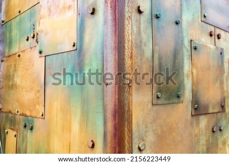 Background with metallic multicolored old coating with patches and bolts