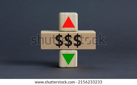 Dollar rates symbol. A wooden cube with arrow symbolizing that dollar rates are going down or up. Beautiful grey table grey background. Business and dollar rates concept. Copy space.