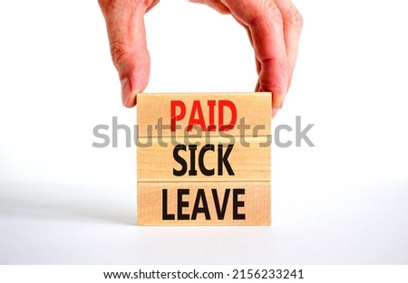 Paid sick leave symbol. Concept words Paid sick leave on wooden blocks. Doctor hand. Beautiful white table white background. Business medical and paid sick leave concept. Copy space.