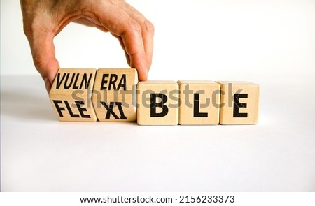 Vulnerable or flexible symbol. Businessman turns wooden cubes and changes words 'vulnerable' to 'flexible'. Beautiful white background, copy space. Business, vulnerable or flexible concept.