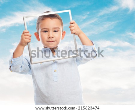 portrait of a little boy looking through an empty frame