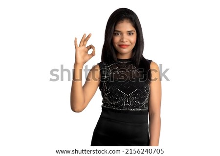 Portrait of a successful cheerful young girl pointing and presenting something with hand or finger with a happy smiling face.