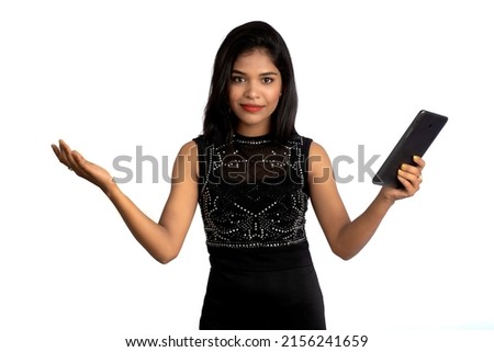 Young beautiful girl holding and using a smartphone or mobile or tablet phone on a white background.