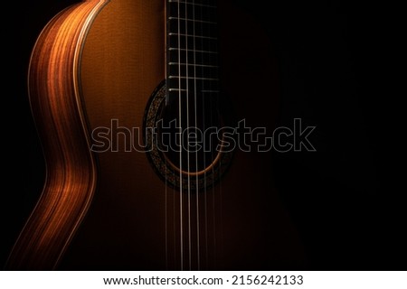 Classical guitar close up, dramatically lit on a black background with copy space Royalty-Free Stock Photo #2156242133