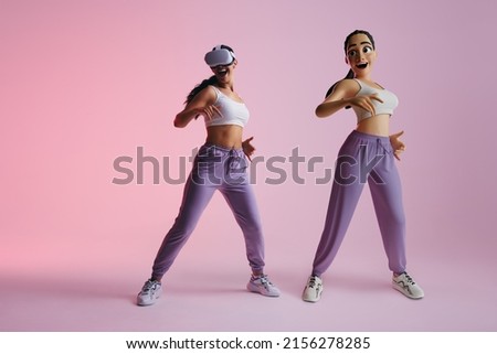 Fun dance moves in the metaverse. Happy young woman dancing as a 3D avatar in virtual reality. Cheerful young woman enjoying a simulation using virtual reality goggles. Royalty-Free Stock Photo #2156278285