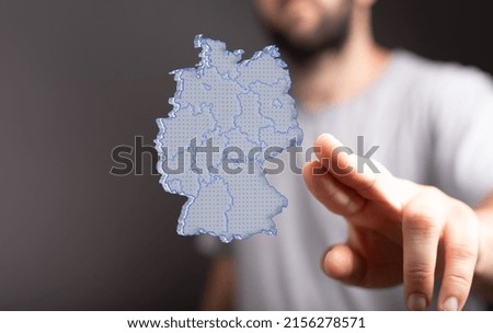 A person pointing at a 3D rendering of the German flag levitating in the air