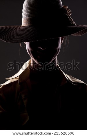 smiling unknown woman with a hat and face in shadow