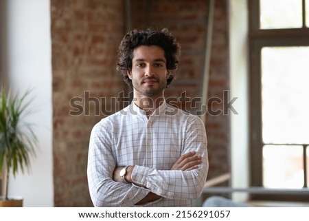 Head shot young millennial Hispanic confident man. Handsome brunette guy pose alone at workplace or loft apartment look at camera. Professional occupation, freelance portrait, homeowner person concept Royalty-Free Stock Photo #2156291057