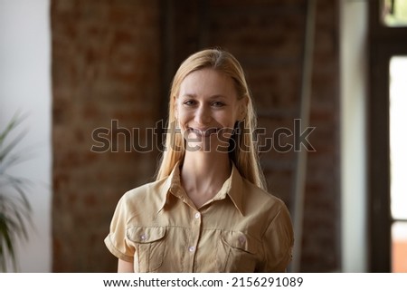 Head shot blonde businesswoman posing indoor smile staring at camera feels happy. Student and higher education, professional occupation, high-school or university qualified teacher concept portrait
