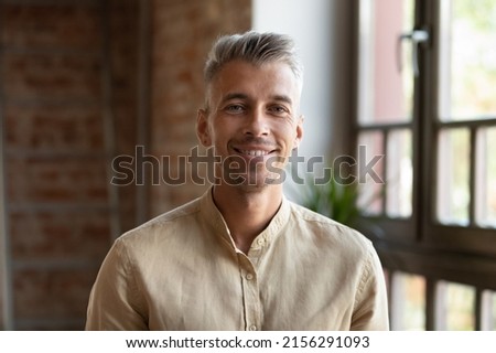 Handsome 30s businessman or employee, head shot. Blond stylish guy posing indoor smiling staring at camera feel optimistic. Professional occupation person, career growth, freelancer portrait concept