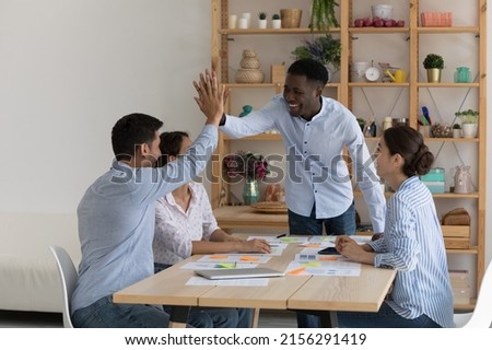 Happy African American coach giving motivating high five to intern for work, study achieve, well done project task. Boss, team leader and employees celebrating teamwork success, good sales result Royalty-Free Stock Photo #2156291419